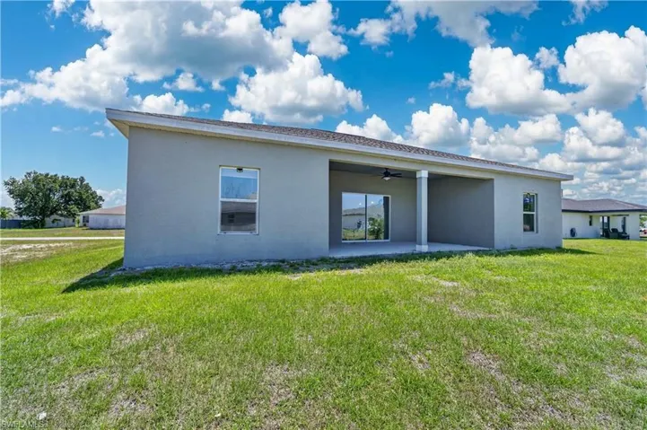 The property features an exterior with light gray walls and a covered patio area