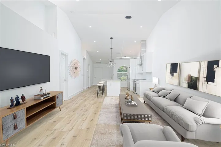 Virtually Staged Living area with baseboards, light wood-type flooring, a high ceiling, and recessed lighting