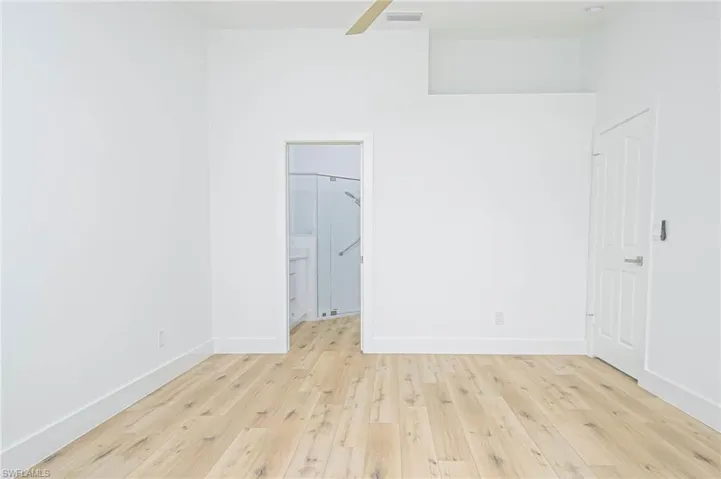 Spare room featuring visible vents, baseboards, ceiling fan, and hardwood / wood-style floors