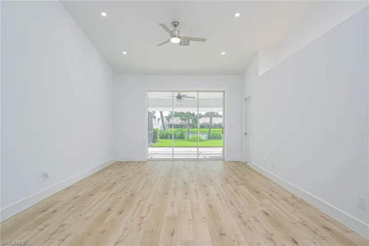Spare room featuring light wood-style flooring, ceiling fan, and baseboards