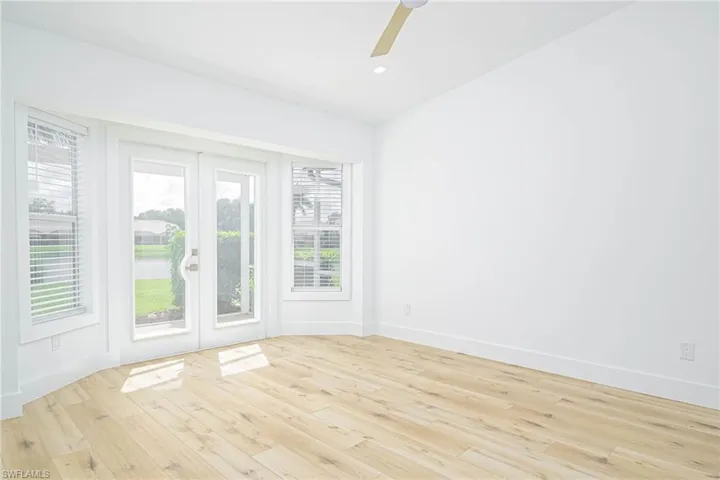 Unfurnished room with french doors, ceiling fan, light wood-style floors, and baseboards