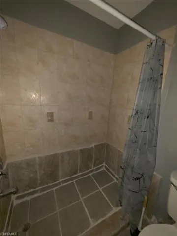 Tiled shower enclosure featuring a combination of light and dark stone-look ceramic tiles