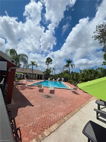 Outdoor swimming pool with integrated spa and surrounding brick paver patio