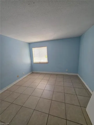 Room featuring neutral-toned square tile flooring