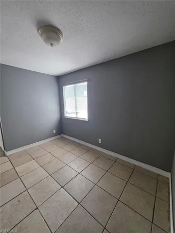 Room featuring neutral-toned tile flooring and gray painted walls