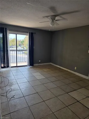 Interior living space featuring tile flooring and a sliding glass door leading to a balcony