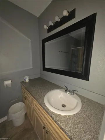 Bathroom vanity featuring an oval sink, chrome faucet, and speckled countertop
