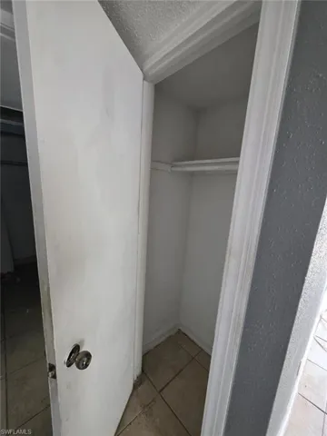 Interior closet with white walls and a single hanging rod