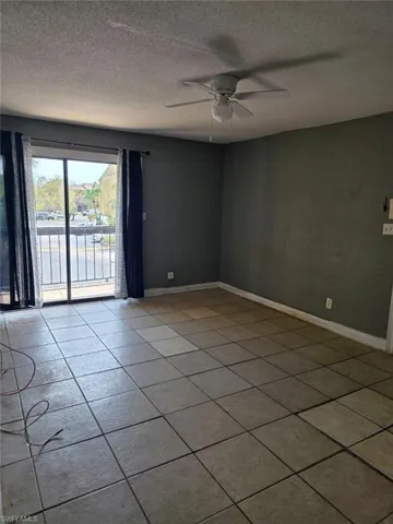 Tiled flooring throughout this living area, featuring a ceiling fan with integrated lighting