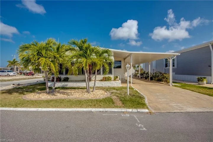 Manufactured / mobile home featuring a carport and concrete driveway