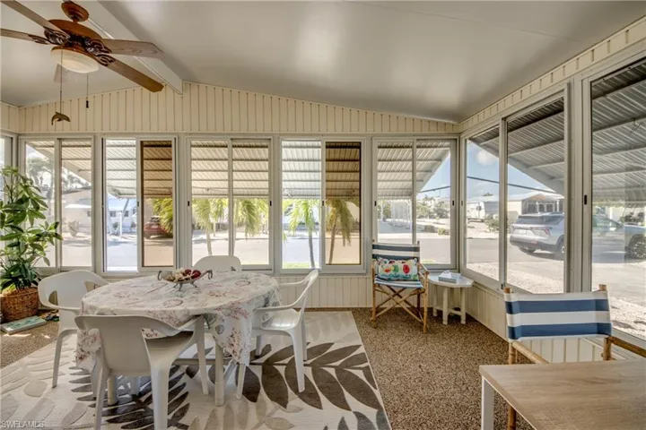Sunroom featuring plenty of natural light, beamed ceiling, and a ceiling fan