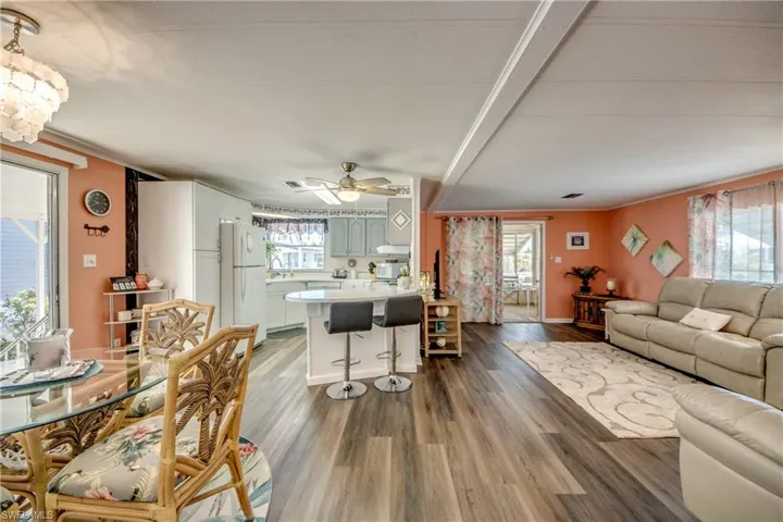 Living area featuring wood finished floors and ceiling fan with notable chandelier