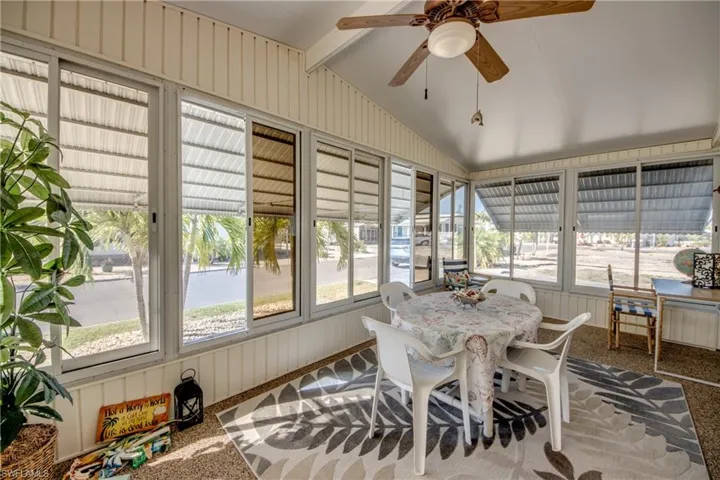 Sunroom / solarium featuring beamed ceiling, outdoor dining area, and ceiling fan