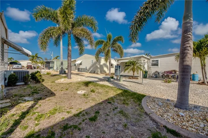 View of yard with central AC unit and fence