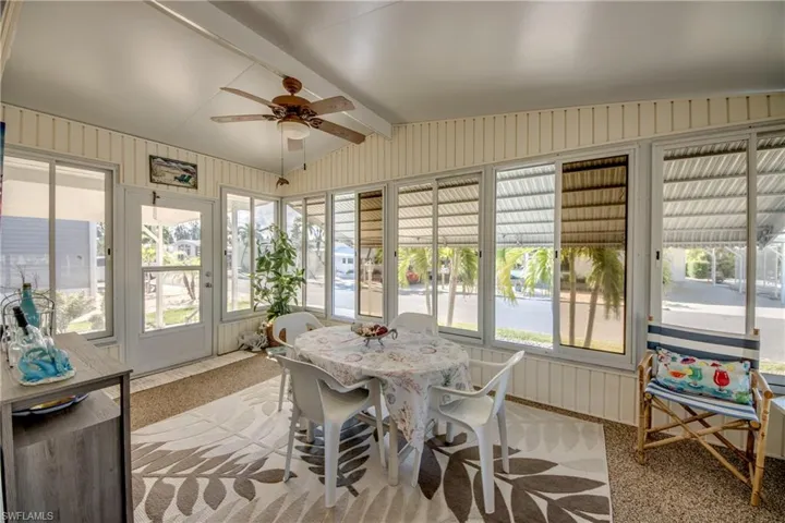 Sunroom / solarium featuring ceiling fan, a wealth of natural light, and outdoor dining space