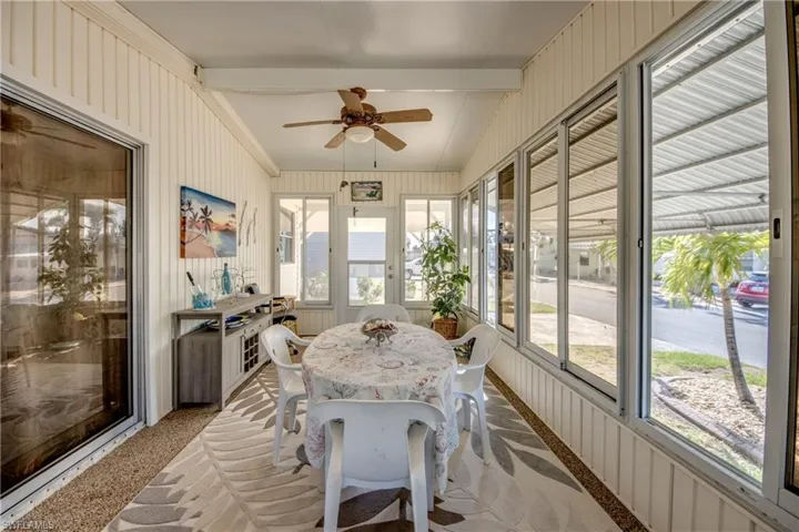 Sunroom featuring ceiling fan and beamed ceiling