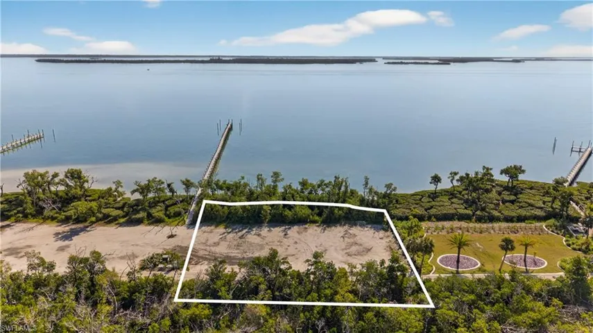 Aerial view of property and surrounding area with property parcel outlined and a nearby body of water