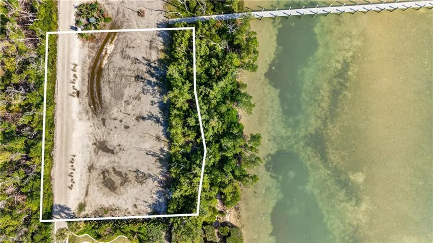 Aerial view of property's location with property parcel outlined and a large body of water