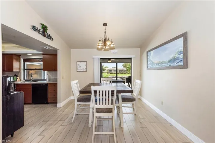 Dining area with light wood finished floors, a chandelier, and baseboards