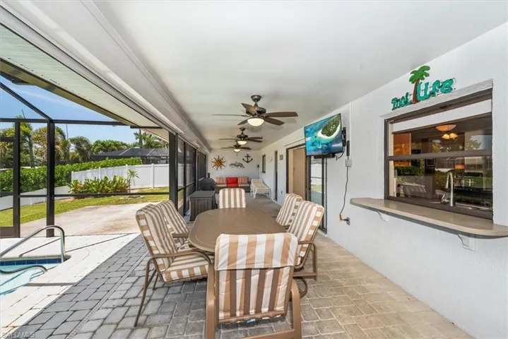 View of patio / terrace featuring a ceiling fan, a lanai, and outdoor dining area
