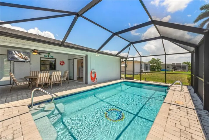 Outdoor pool with a patio, a ceiling fan, and glass enclosure