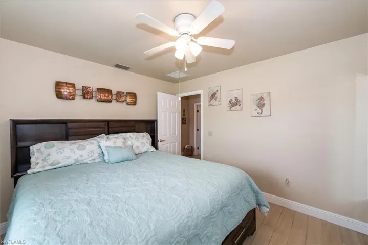 Bedroom with baseboards, wood finished floors, and a ceiling fan