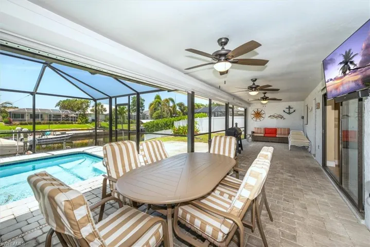 Sunroom featuring ceiling fan, a water view, an outdoor living space, and outdoor dining area