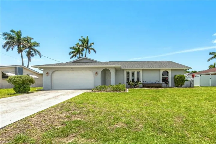 Ranch-style house with stucco siding, an attached garage, and concrete driveway