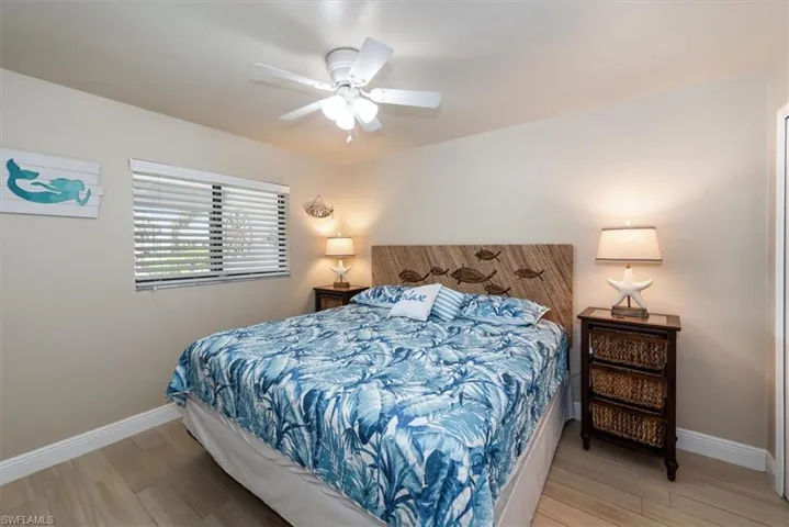 Bedroom with light wood finished floors, baseboards, and ceiling fan