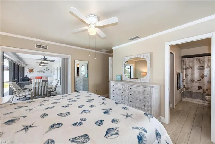 Bedroom featuring light wood-type flooring, crown molding, and a ceiling fan
