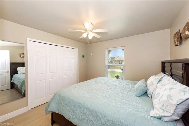 Bedroom with light wood-style flooring, a closet, baseboards, and ceiling fan