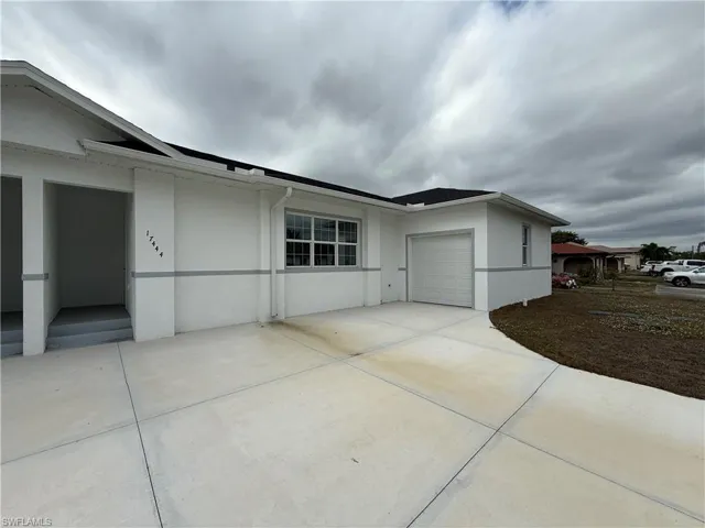 View of property exterior with stucco siding, an attached garage, and concrete driveway