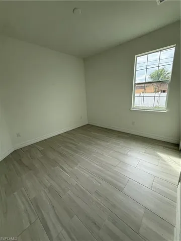 Empty room with baseboards and wood tiled floors