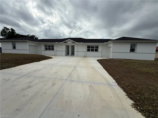 Single story home with concrete driveway, stucco siding, and a garage