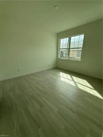 Spare room featuring baseboards and wood tiled floors