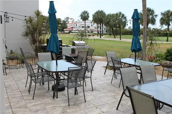 View of patio with outdoor dining space and a grill