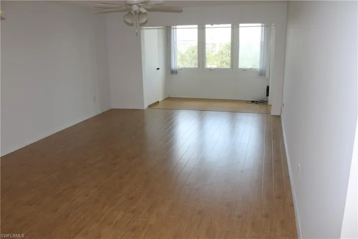 Empty room featuring a ceiling fan, light wood-style floors, and baseboards
