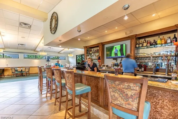 Indoor wet bar featuring light tile patterned flooring and a paneled ceiling