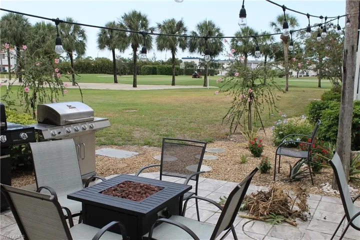 View of patio / terrace with an outdoor fire pit, golf course view, and grilling area