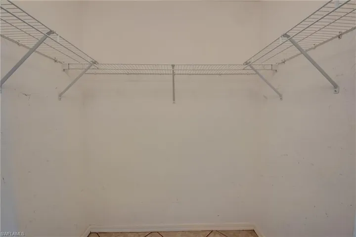 Walk in closet with light tile patterned floors