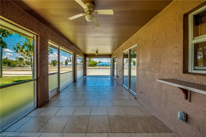 Unfurnished sunroom featuring a ceiling fan