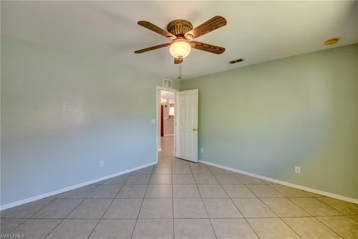 Unfurnished room with a ceiling fan, baseboards, a smoke detector, and light tile patterned floors