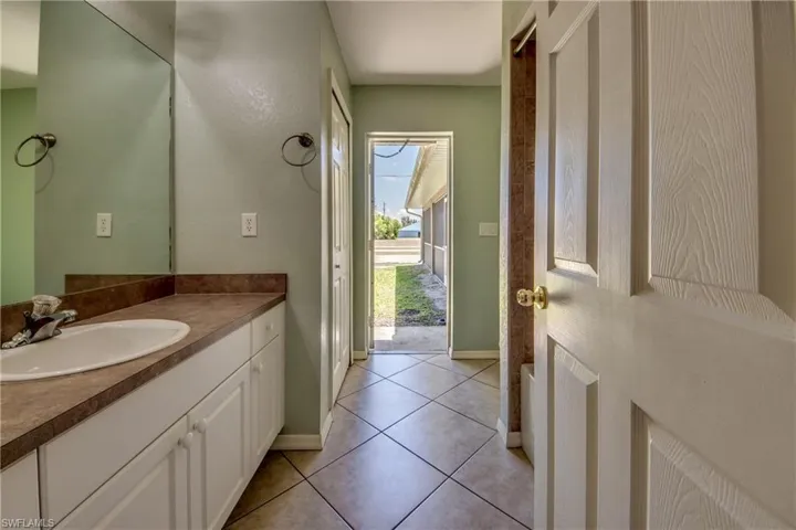 Bathroom with baseboards, vanity, and tile patterned flooring