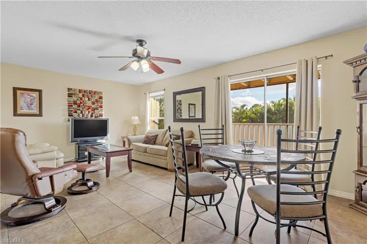 Tiled dining space with a textured ceiling and ceiling fan
