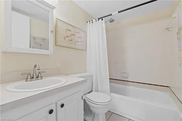 Full bathroom featuring toilet, vanity, shower / bath combination with curtain, and tile patterned floors