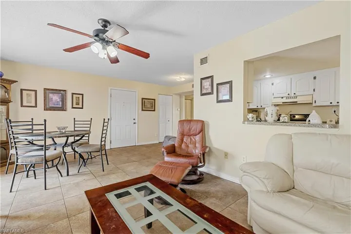Tiled living room featuring a textured ceiling and ceiling fan