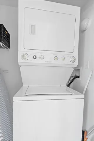 Laundry area with stacked washer and clothes dryer