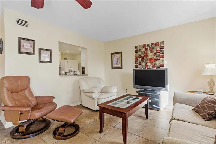 Living room with light tile patterned flooring and ceiling fan