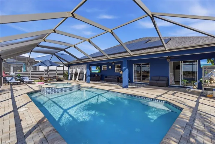 Integrated pool / spa featuring a sunroom, glass enclosure, and a patio area