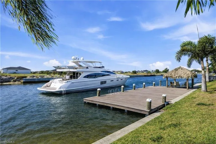 Dock area featuring a water view and a lawn